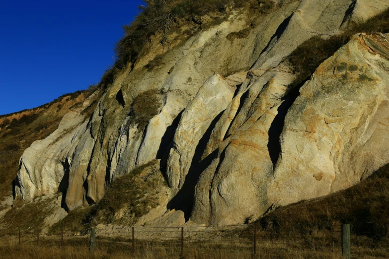 a fence is in front of the rock cliff