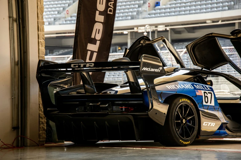 a blue race car in a corner with a tall sign