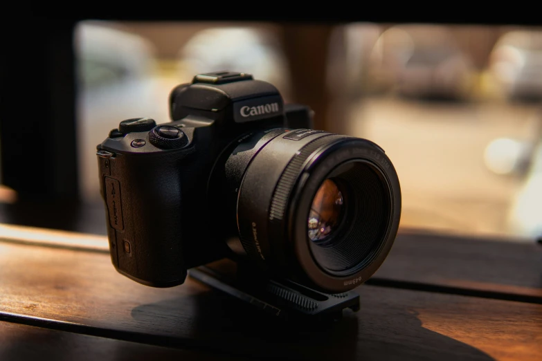 a canon camera sits on top of a wooden table