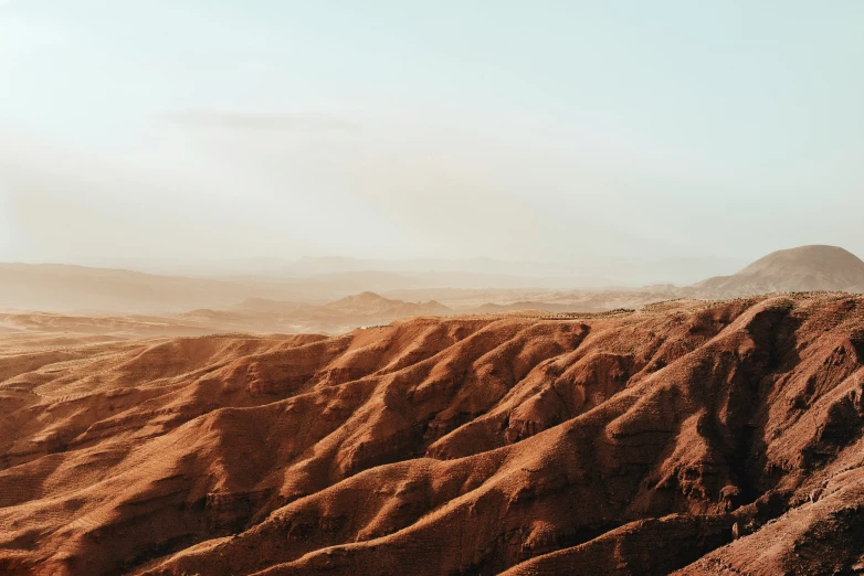 barren landscape of red dirt and small hills