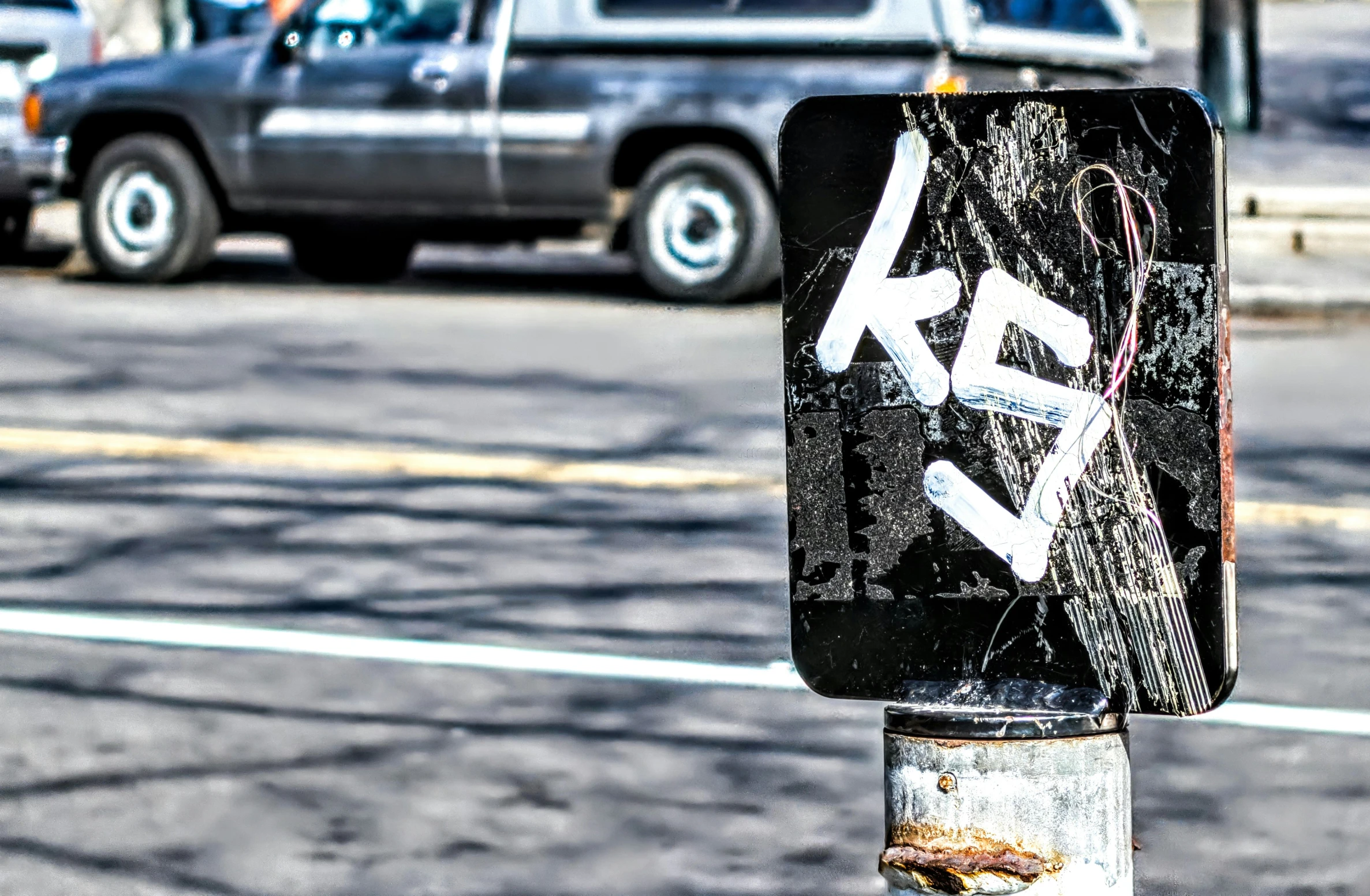 an old and worn street sign is in the middle of traffic