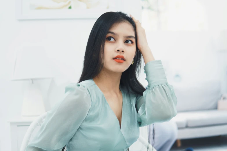 the asian woman poses in front of a white wall