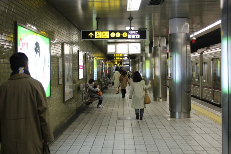 several people are waiting for the train at the subway station