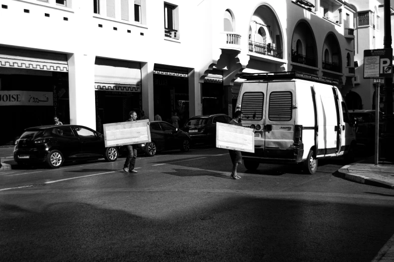 a group of people are walking on the street with boxes