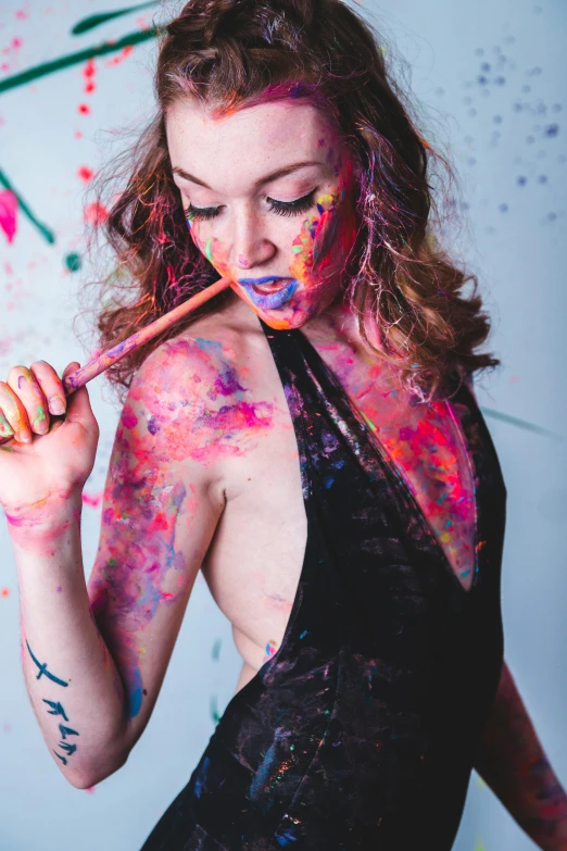 a woman covered in colors holding an arrow