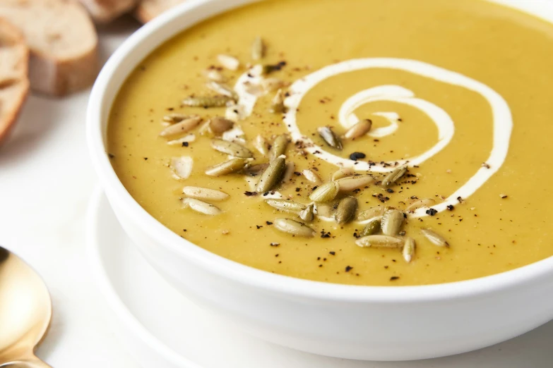 a bowl full of yellow soup and bread