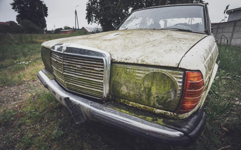 a old dirty truck sitting out in the field