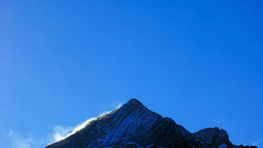 a snow - covered mountain with clouds in the sky