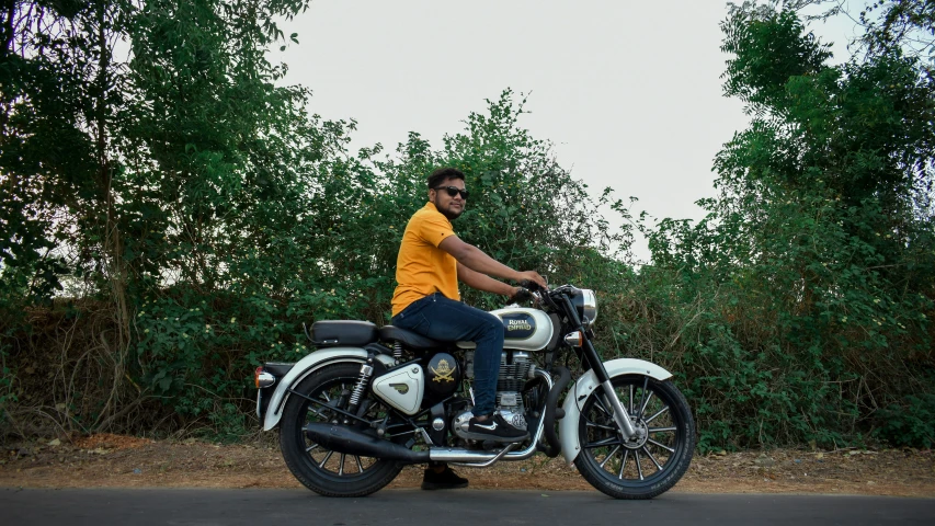 a man wearing a yellow shirt is sitting on a motorcycle