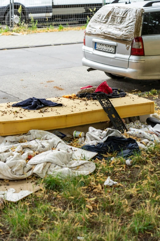 trash near a car parked at the side of the road