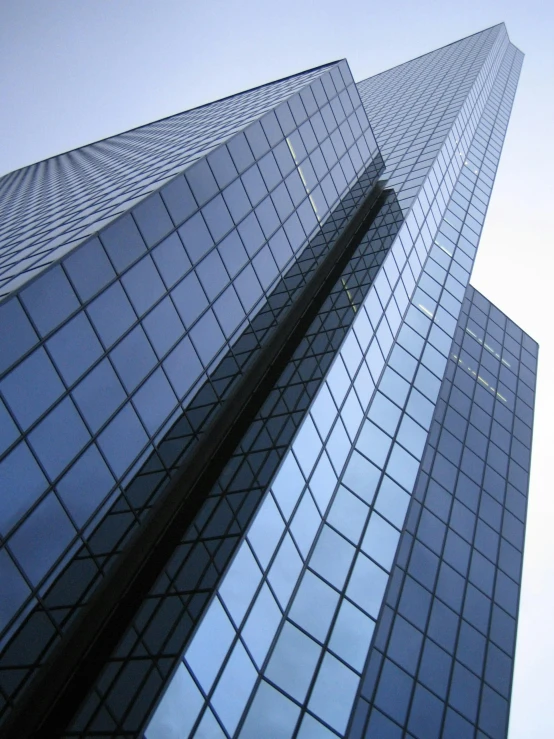 two very tall buildings with glass windows that are both taller