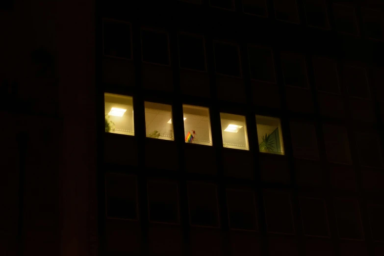 people standing in the windows at night, looking out