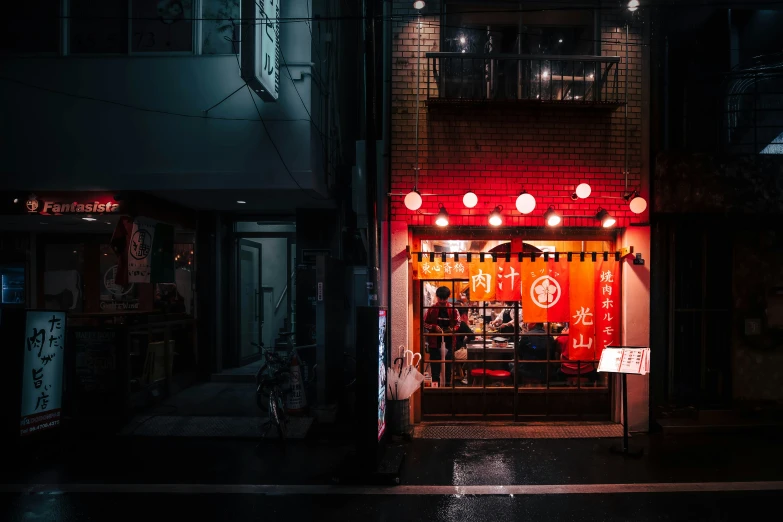 a person standing in front of a building with red lighting