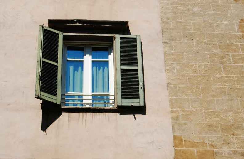 a window with closed blinds is seen from inside