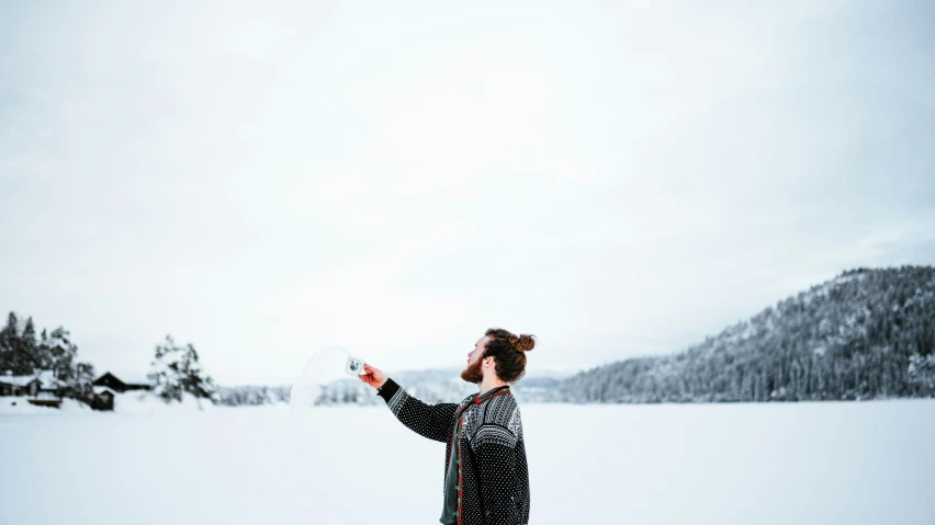 a woman in a snow covered field holding a frisbee