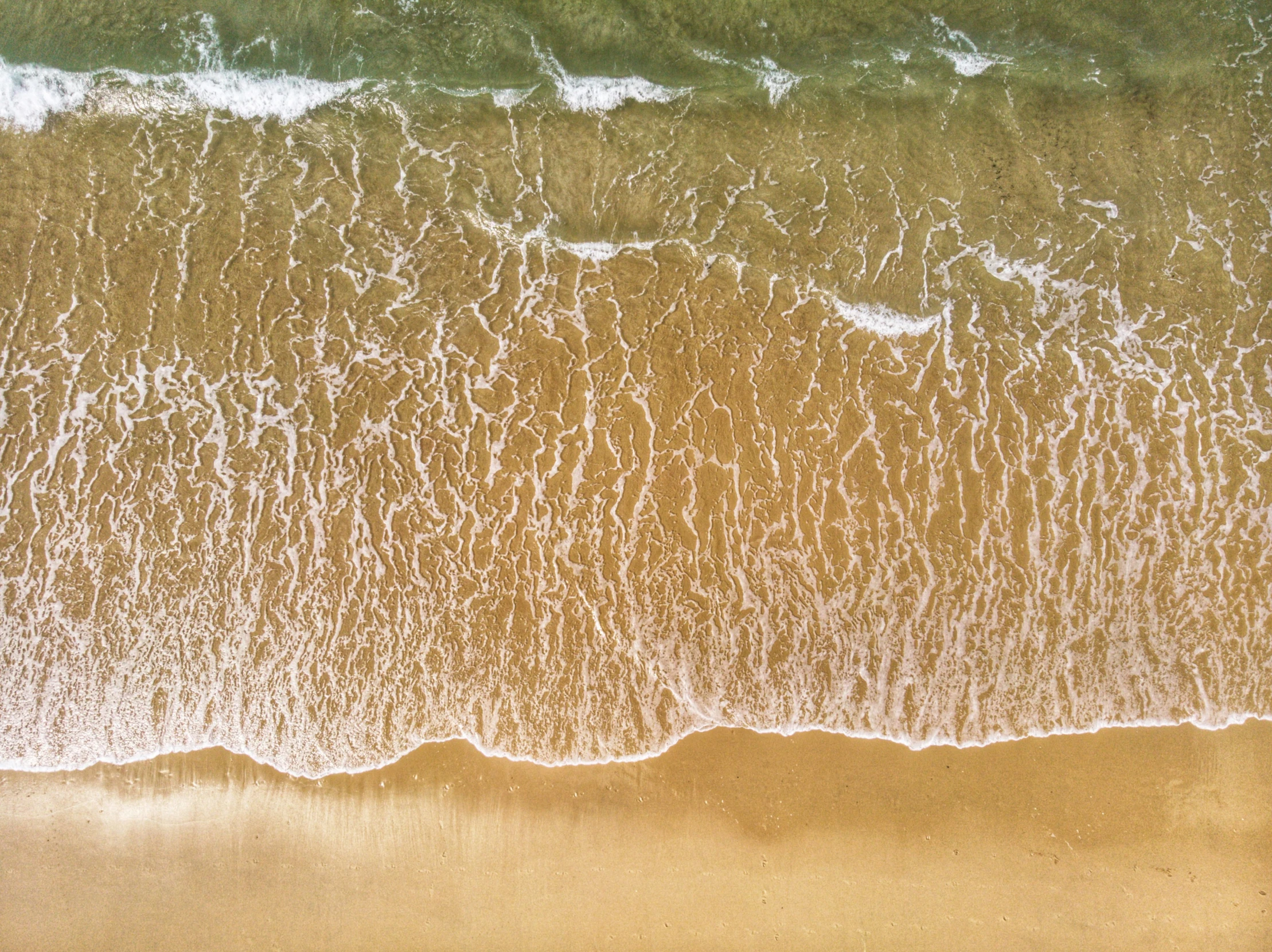 an aerial view of the ocean with many waves