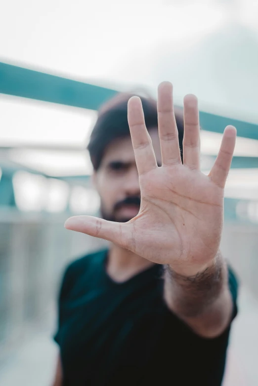 a man holding his hand up in front of his face