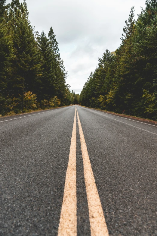 an empty road with two white lines on the side