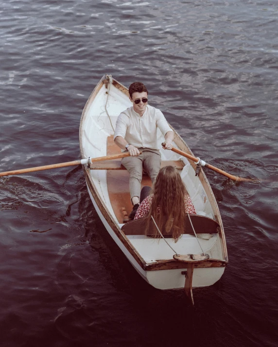 a man and two women are riding on a small row boat