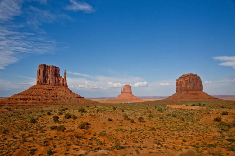 a view of desert with small es and rocks in the background