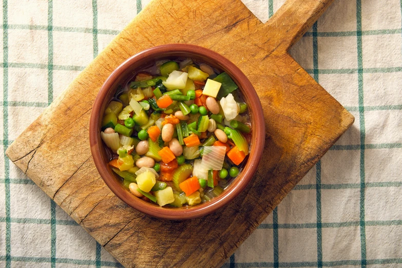 a close up of a bowl of soup on a wooden tray