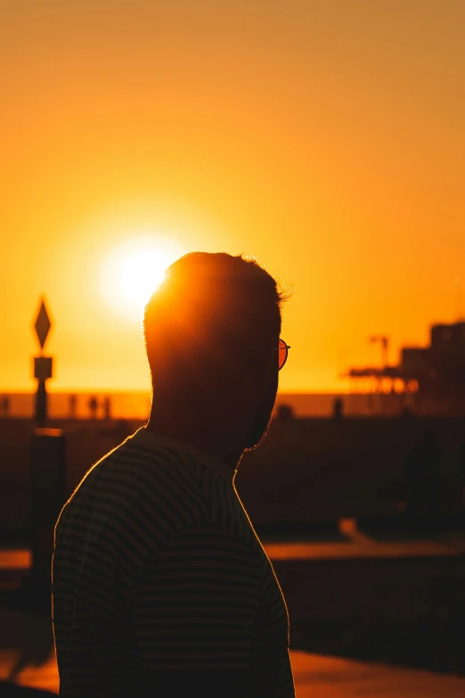 the man looks into the distance in the sunset