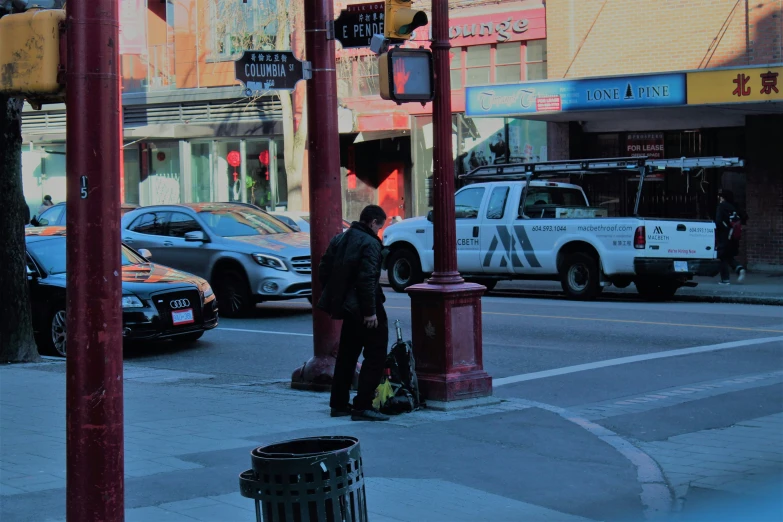 a man walking down the sidewalk on a busy street