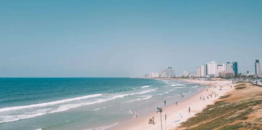 a group of people at the beach in front of some buildings