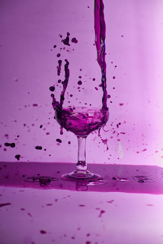 there is a glass with purple liquid on it