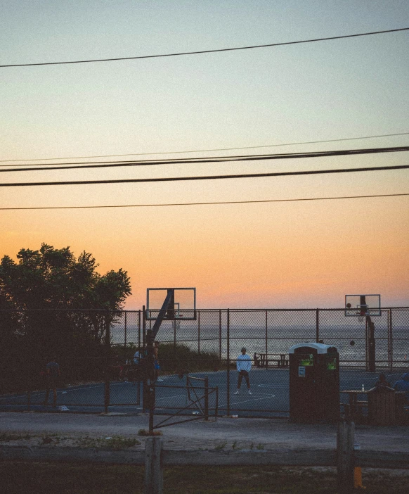 the view of the fence, and a building with the ocean in the background