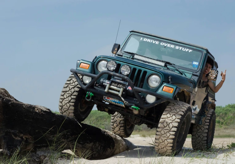 a person standing on top of a green jeep