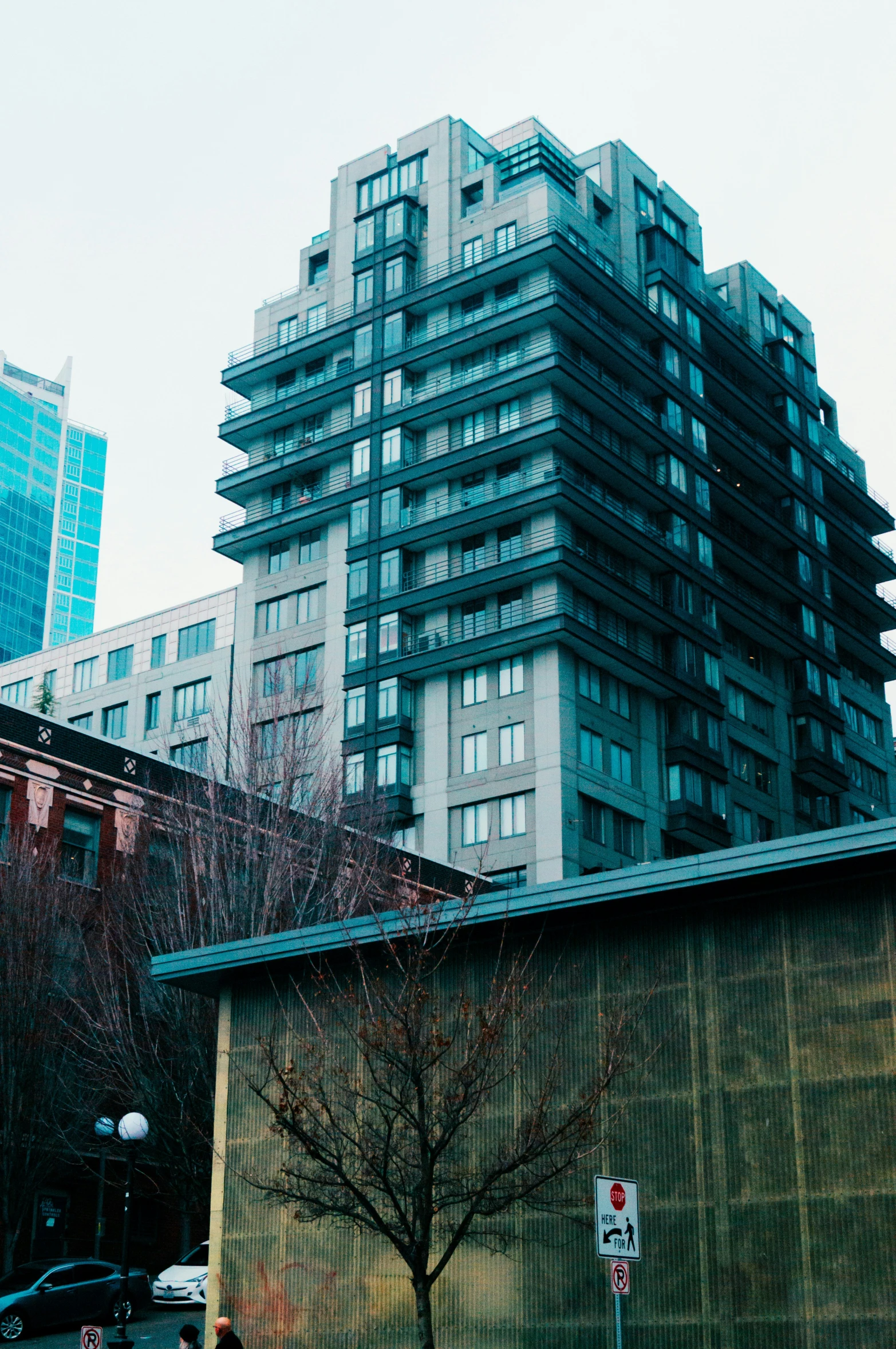 an old building next to a huge building with a street sign in front of it