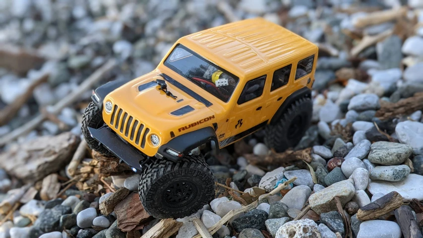 a toy car is on the rocks near the sand