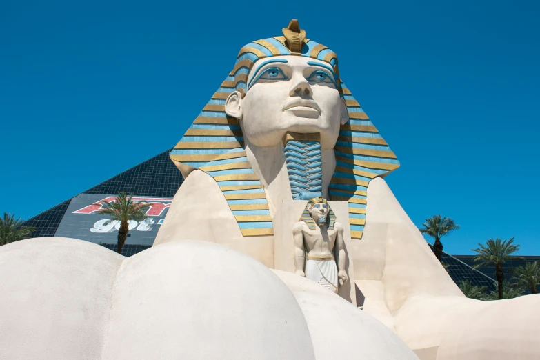 an egyptian pharaoh statue standing in front of the entrance to an airport