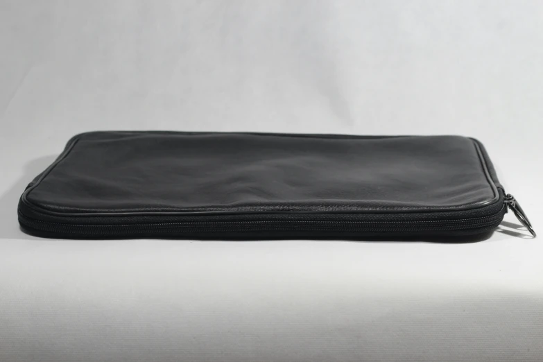 a black case sits on top of a white sheet