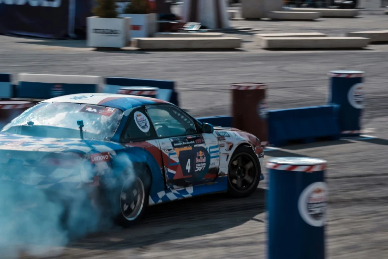 a blue race car with orange and white smoke