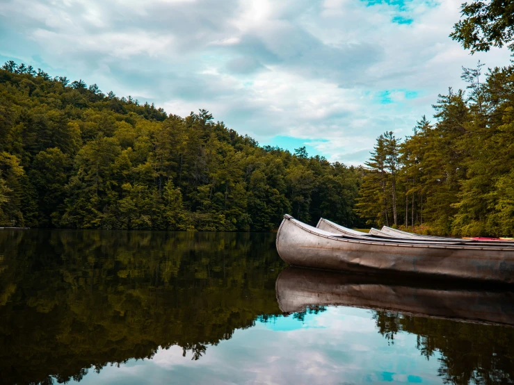 the canoe is on the edge of a calm lake