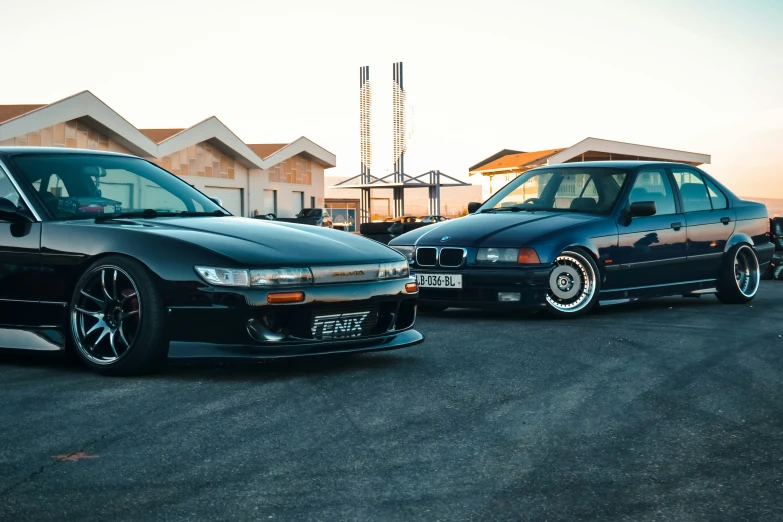 two cars in front of some buildings one has its doors open