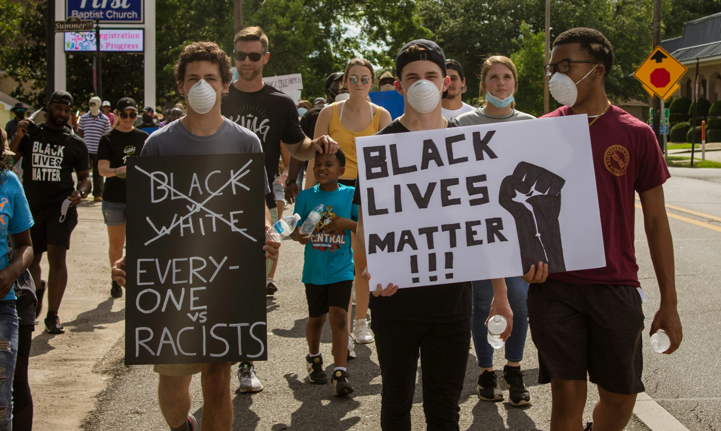 people holding black lives matter signs and masks