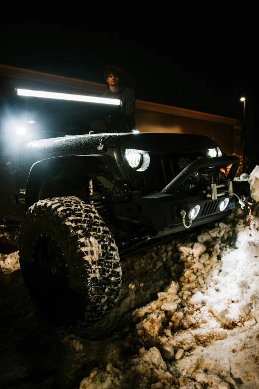 the man is standing next to a truck with some snow on it