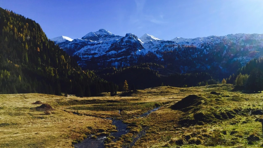 the sun is shining on the mountains and the river