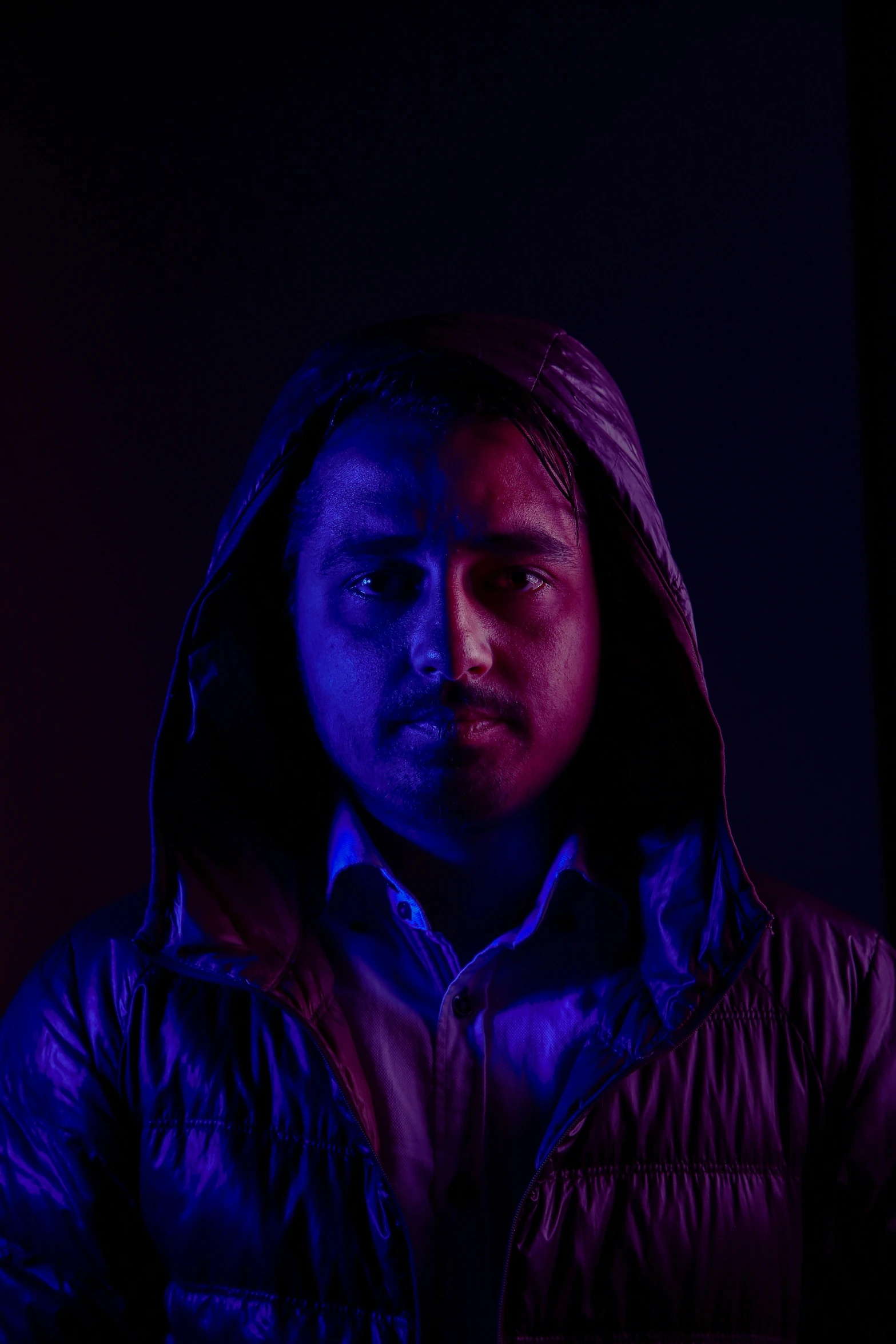 a guy with a hooded jacket, wearing dark lighting