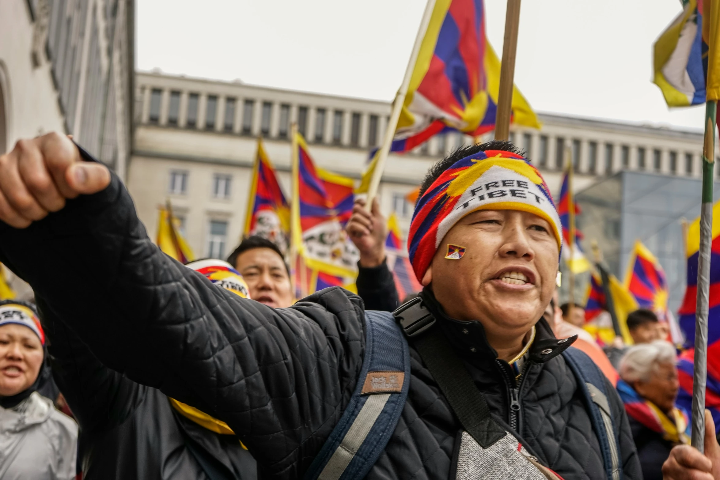 several people holding flags and pointing to soing in the sky