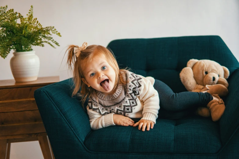 small child lying down on a couch with stuffed toys