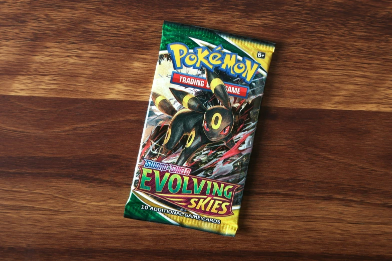 a folded package of pokemon trading cards laying on a wood table