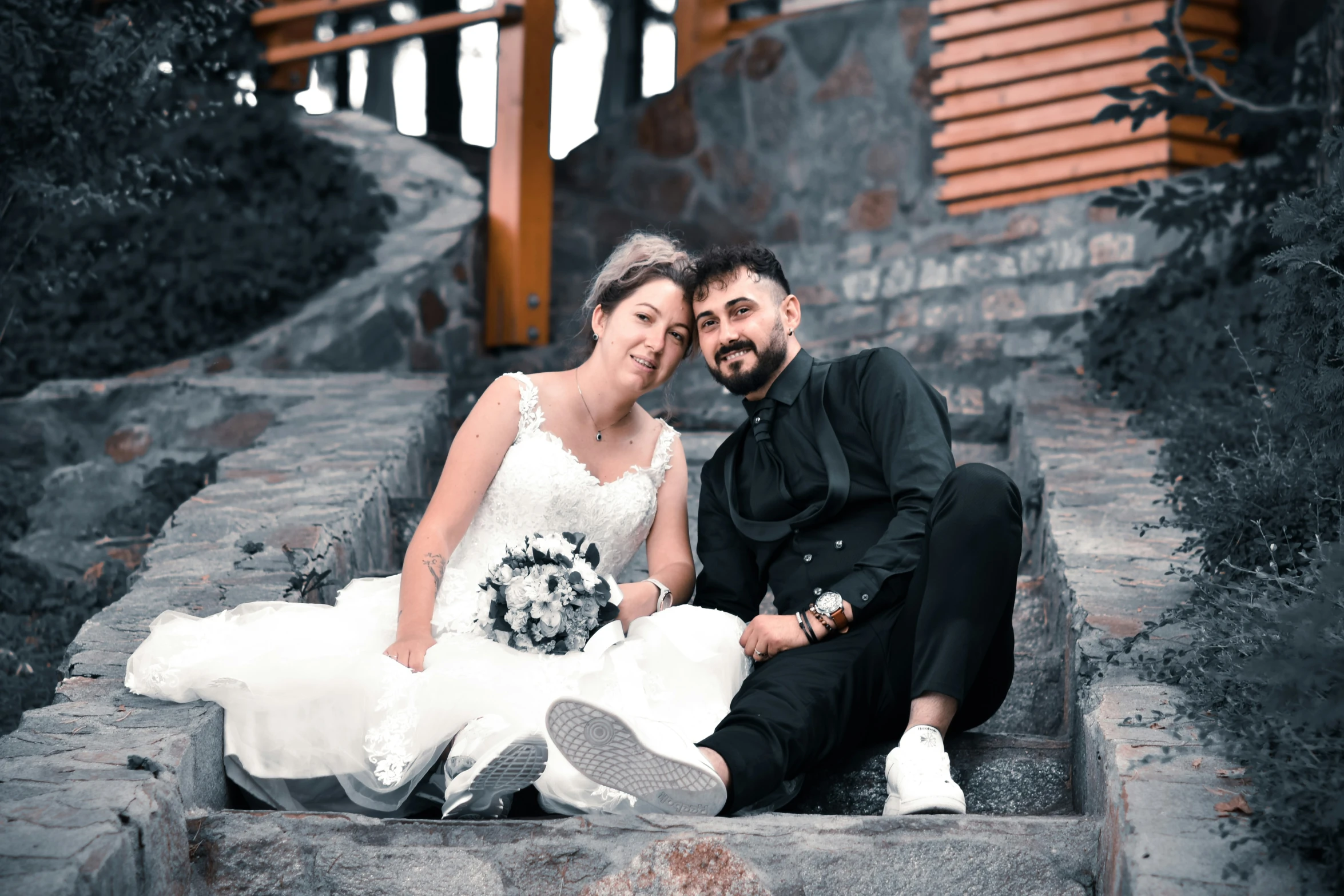man and woman sitting on steps posing for po