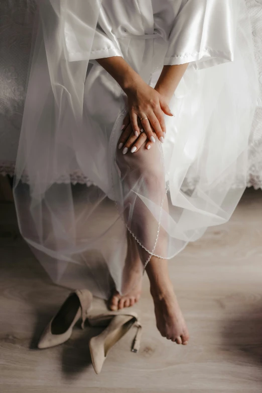 a woman with her legs crossed standing on a pair of heels