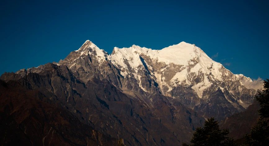 a mountain view from below, with trees at the base