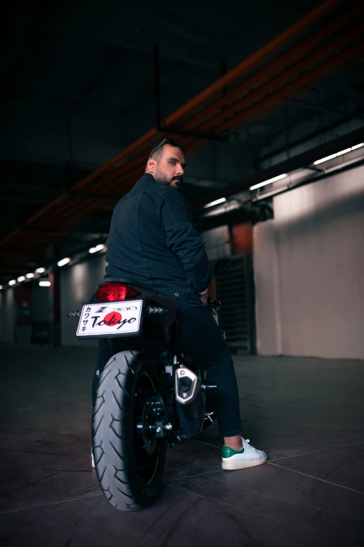 a man in black jacket sitting on a motor bike