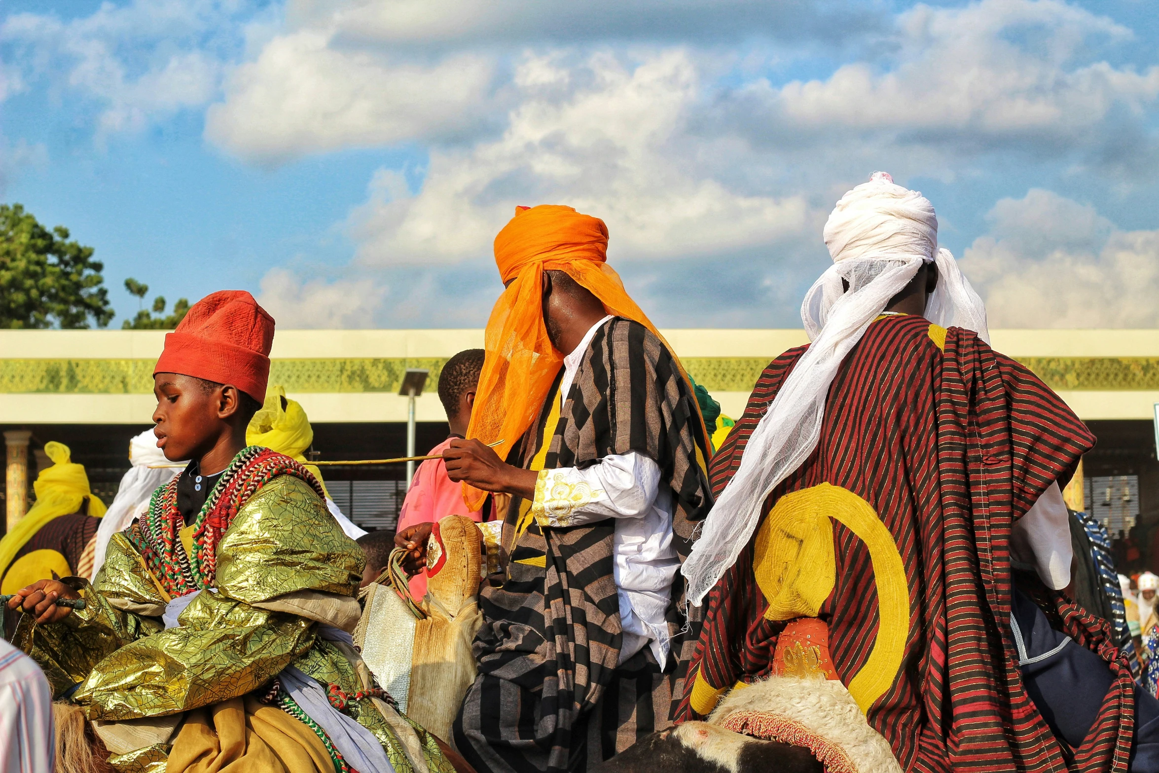 people sitting on a pile of dirt in brightly colored clothes